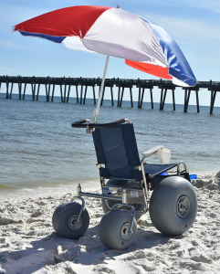 beach wheelchair connected to an umbrella looking at the ocean